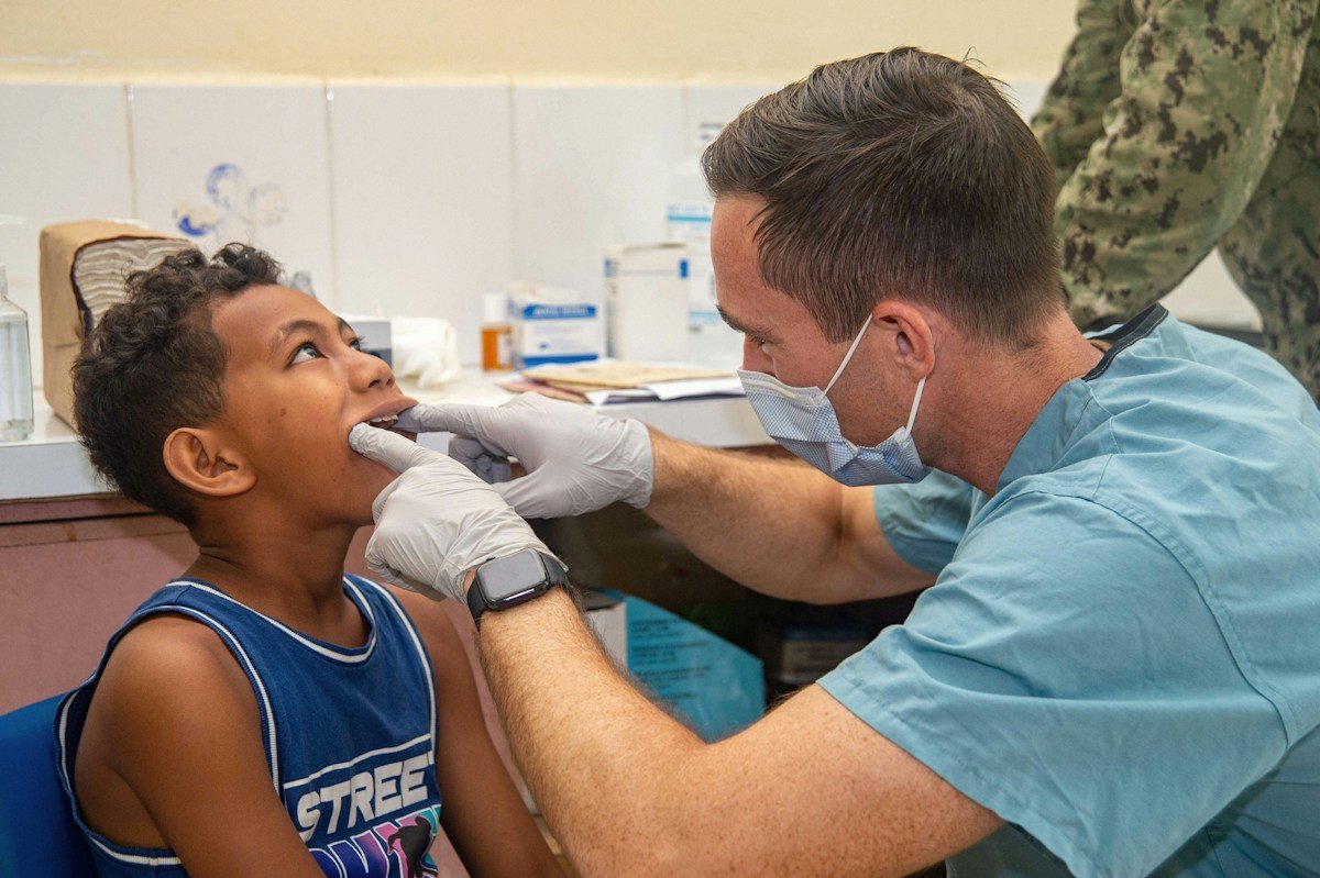 A dentist checking a young boy's teeth