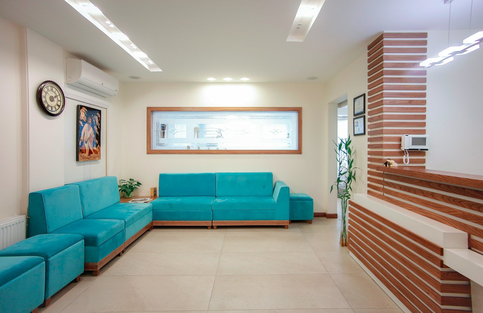A calm waiting room with a blue sofa and plants